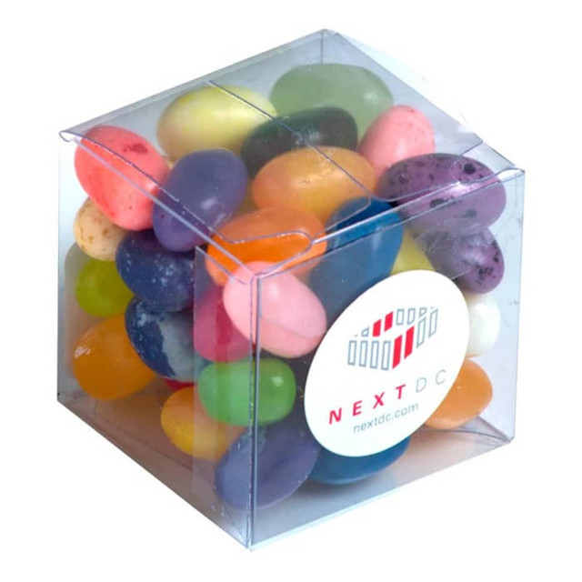 A clear cube filled with colourful jelly beans in various flavours, featuring a logo on the front.