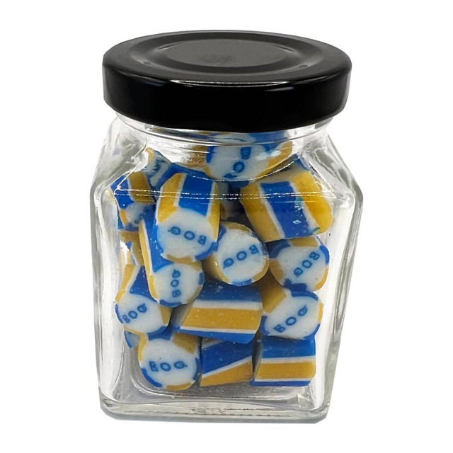 A small glass jar filled with blue and yellow rock candy pieces, featuring a black lid and a logo on the jar.