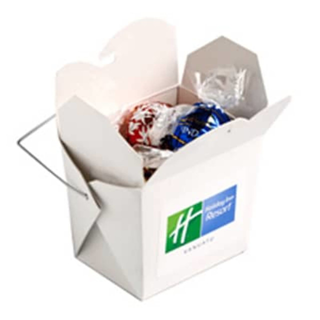 A white cardboard noodle box containing five Lindor Lindt balls, featuring a branding logo on the side.