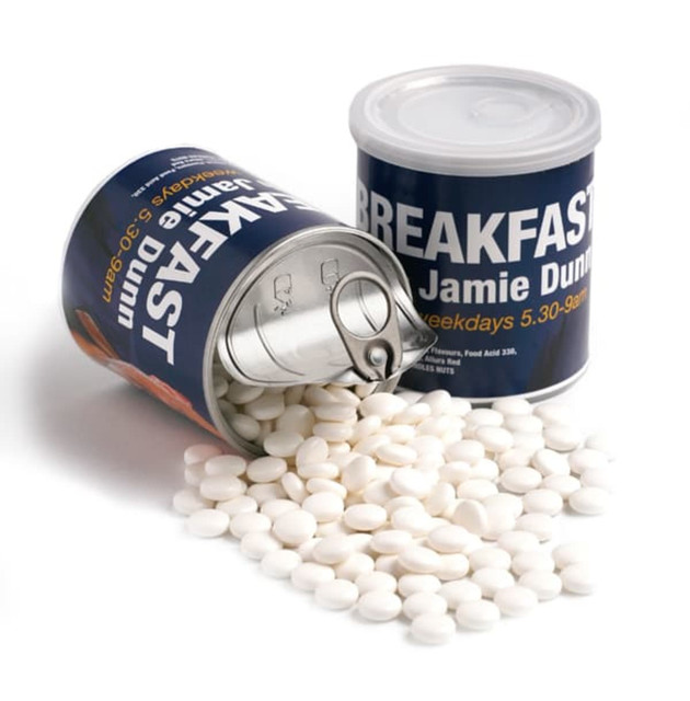A canister with a pull tab filled with white mints, tipped over with mints spilling out. The can has a logo.