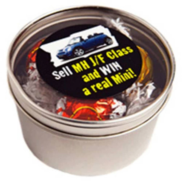 A silver round tin filled with colorful Lindt chocolate balls. The tin has a label with a logo.