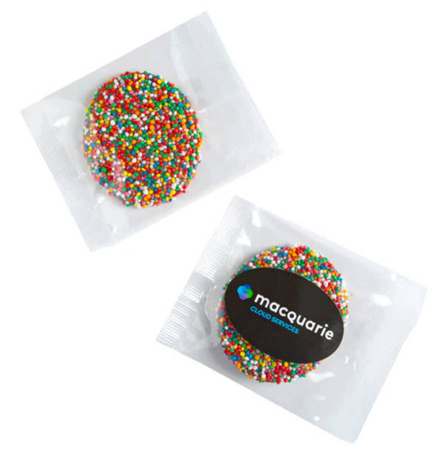 A colourful chocolate freckle in a clear cello bag, featuring vibrant sprinkles in red, green, blue, and yellow.