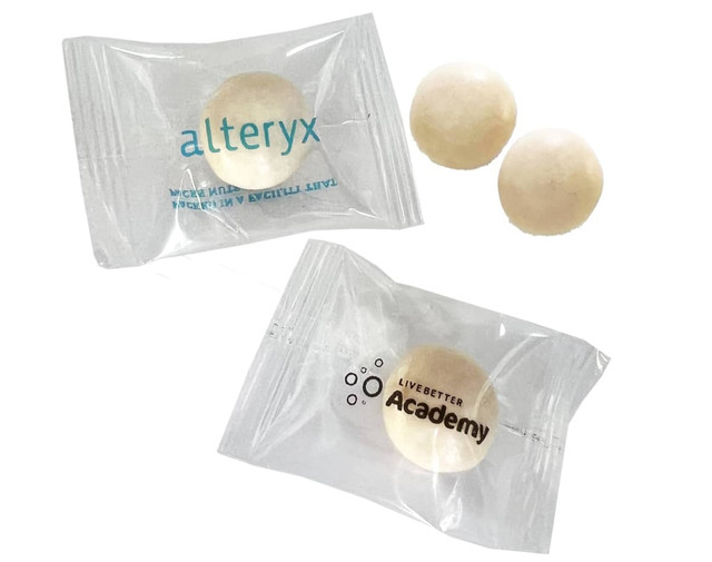 A pack of large, white chewy mints with two individual mints visible inside a clear wrapper featuring logos.