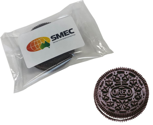 A chocolate biscuit with a cream filling, presented in a clear plastic wrapper with a logo.