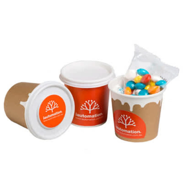 A coffee cup with a brown exterior and a white lid, filled with chewy fruit candies in vibrant colours.