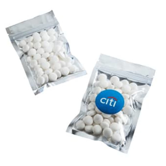 Silver zip lock bags containing white mints, featuring a logo on one of the bags.
