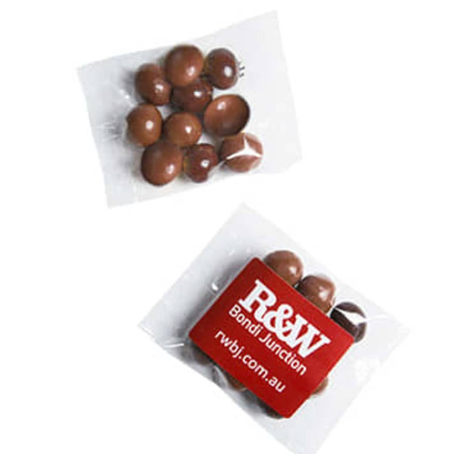 Chocolate coated coffee beans in a clear package, featuring brown and dark chocolate colours. Includes a branding logo.