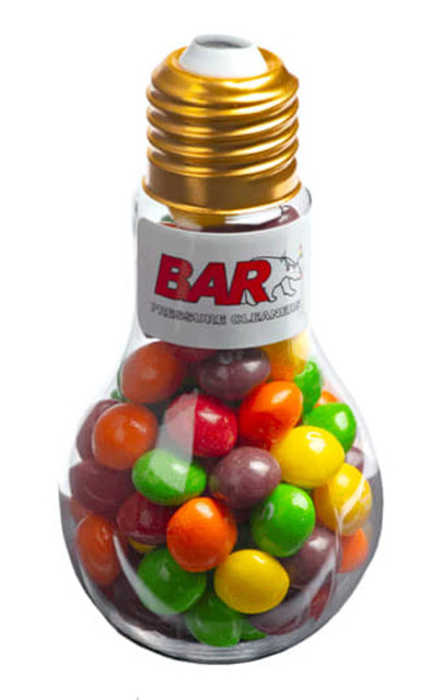 A light bulb-shaped container filled with vibrant Skittles in various colours, featuring a gold cap and a logo.