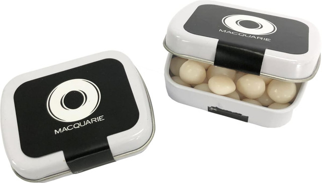 A small rectangular tin with a black lid, filled with white mints. The tin features a branding logo on top.
