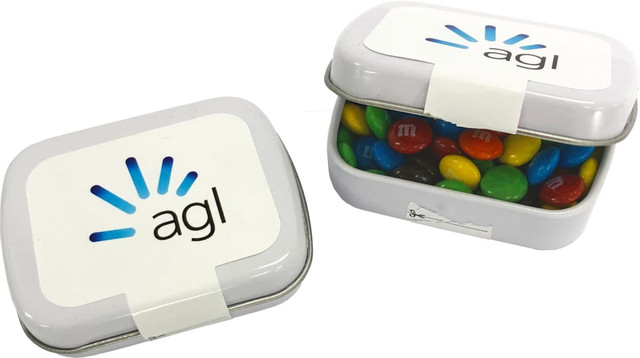 A small rectangular tin filled with M&Ms in various colours, featuring a logo on the lid.