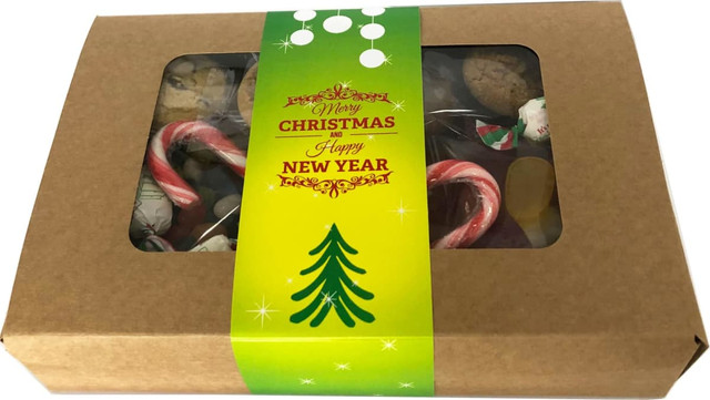 A kraft gift box featuring an assortment of cookies and candy canes, adorned with a decorative band.