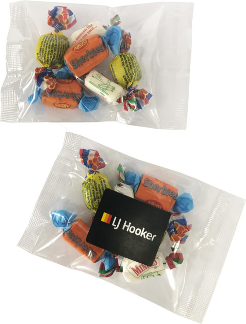 A bag containing assorted mixed lollies in bright colours, with a branding logo on the packaging.