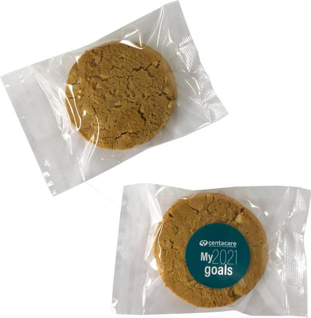 A round, light brown cookie packaged in clear plastic, featuring a logo on the front.