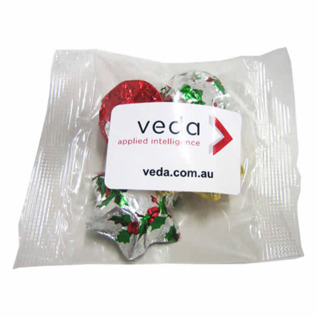 A cello bag filled with assorted Christmas chocolates in festive foil wrappers, including red, silver, and gold.