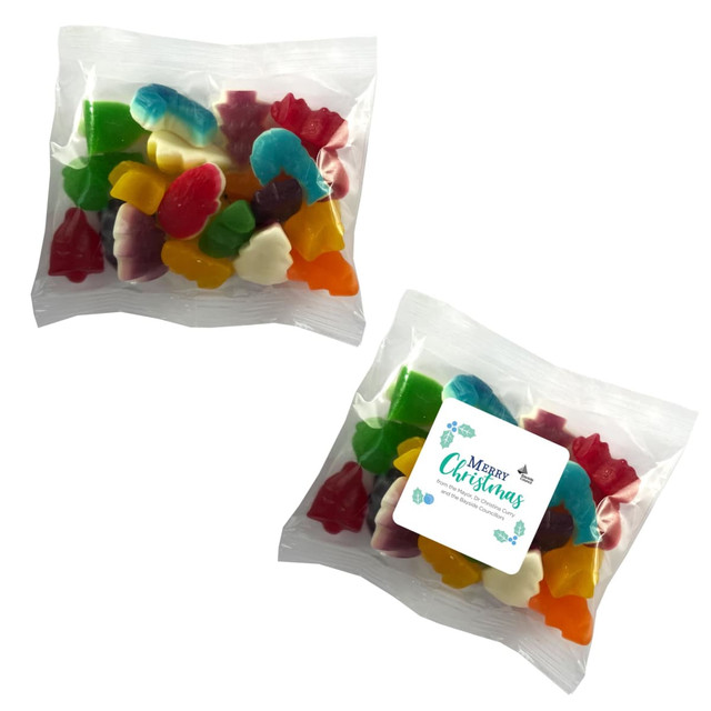 A clear bag of mixed lollies in various shapes and vibrant colours, including red, green, yellow, and blue.