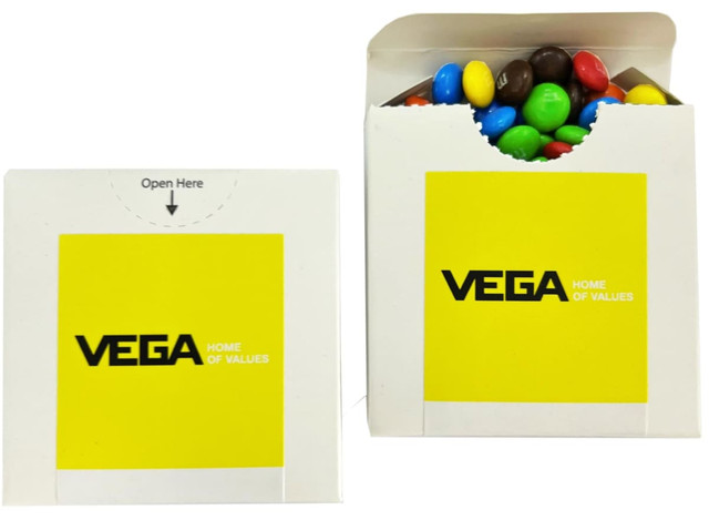 A cardboard box with a flip lid containing colourful choc beans, including blue, green, yellow, red, and brown M&Ms.