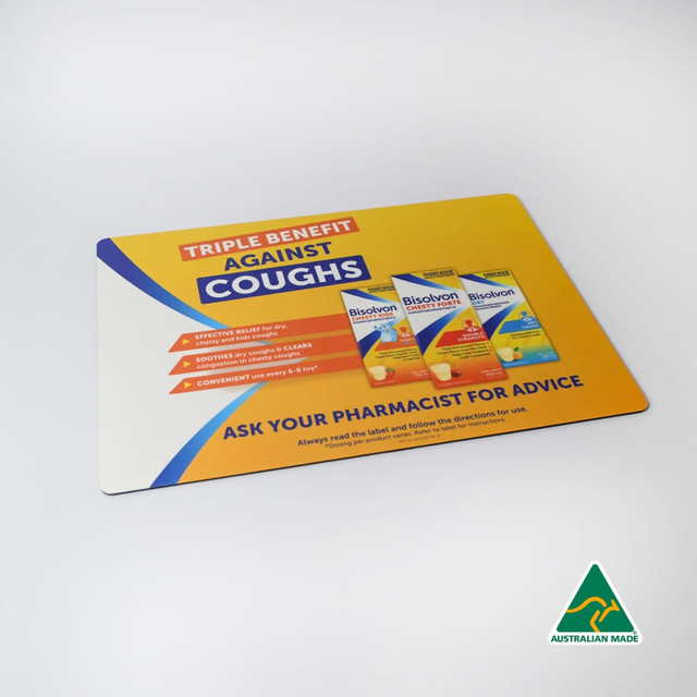 A colourful counter mat featuring a promotional design with products and a logo, highlighting benefits against coughs.