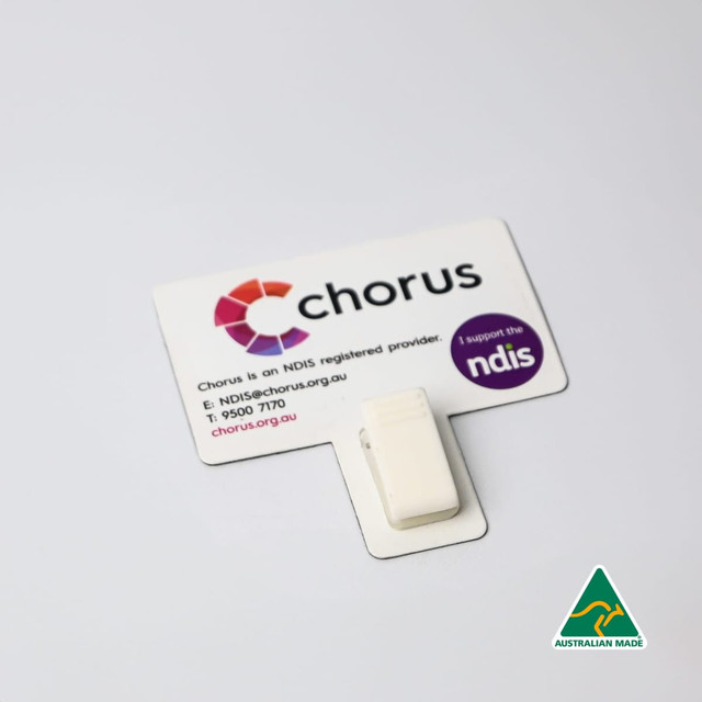 A white T-Magnet with a clip, attached to a printed card featuring logos and contact details.