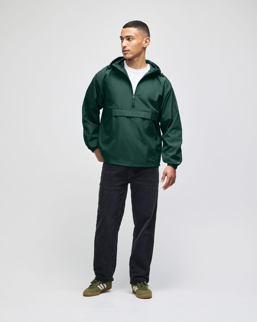 An olive green packable anorak jacket, featuring a hood and half-zip, worn by a model with black pants.