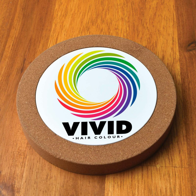 A round cork wireless charger featuring a colorful spiral design and a logo on a white background.