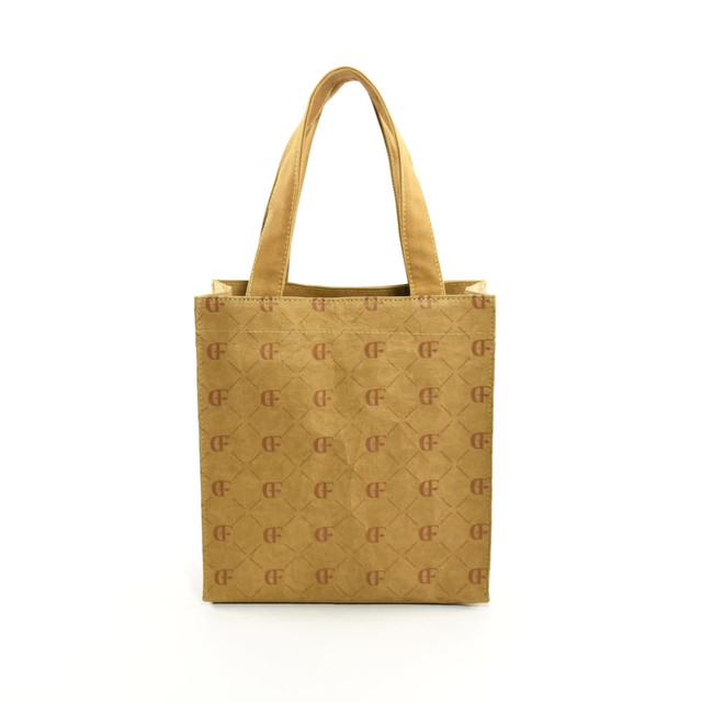 A kraft paper tote bag in a brown shade, featuring two handles and a patterned design. It has a logo on the front.