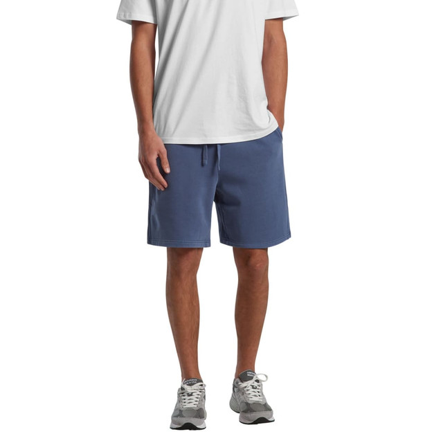 Faded blue sports shorts with pockets, featuring a drawstring waistband and a logo. Model wearing a white t-shirt and shoes.