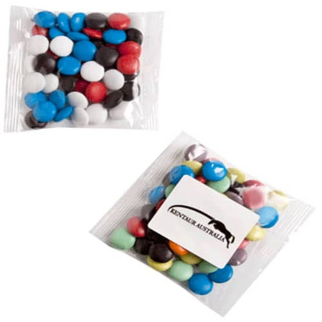 A packet of mixed chocolate beans in various colours, including blue, red, white, black, and green.