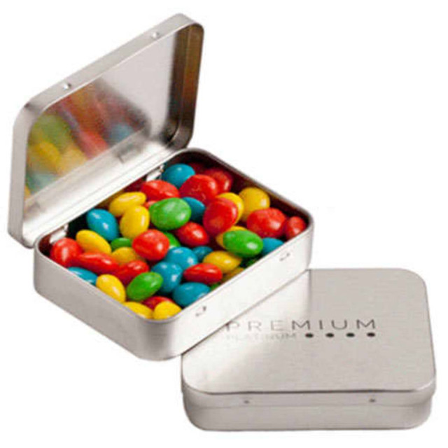 A rectangular silver tin filled with colourful chewy fruit candies in red, green, yellow, and blue.