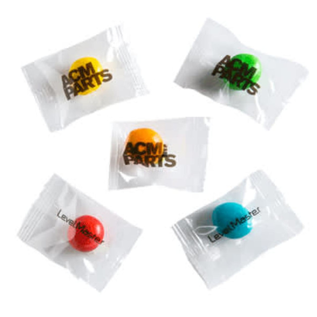 A collection of individually wrapped chewy fruit sweets in red, green, blue, and yellow, displayed in a clear bag.