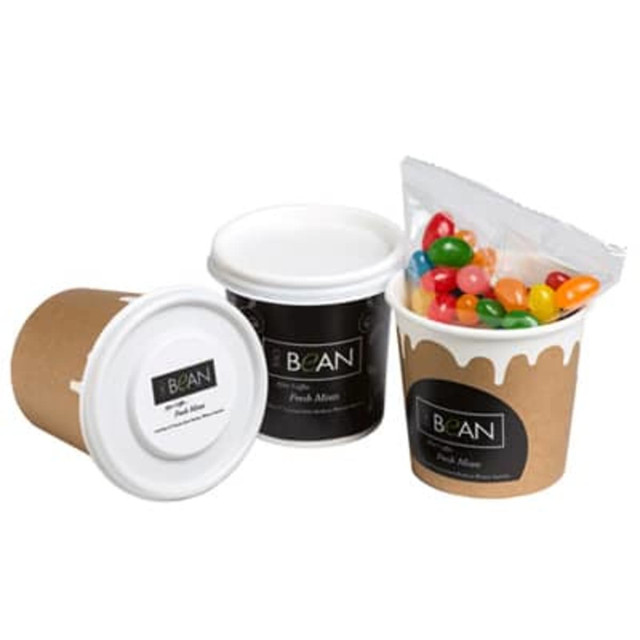 A coffee cup with a lid contains colourful jelly beans, featuring a brown paper exterior and a black branding label.