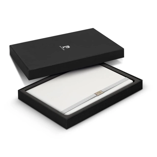 A sleek black gift box containing a white notebook with a metallic strap, featuring a brand logo.