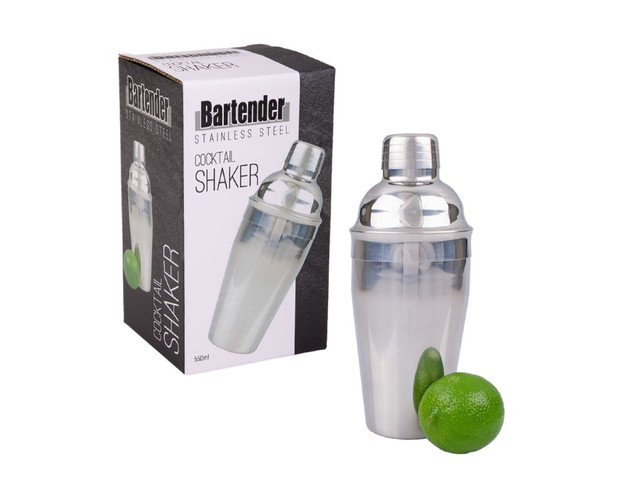A stainless steel cocktail shaker with a clear lid, accompanied by a green lime, placed beside its packaging.