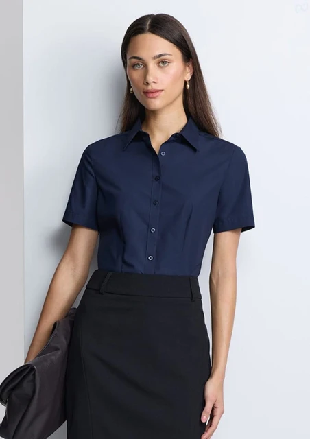 A navy women's short sleeve shirt with a collared neckline and buttons, paired with a black skirt.