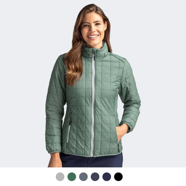 A women's jacket in green with a quilted design, featuring a zip front and one hand in the pocket.