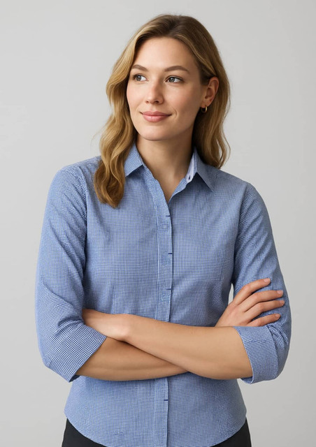 A women's button-up shirt in blue with a subtle checked pattern and 3/4 sleeves, featuring a logo.
