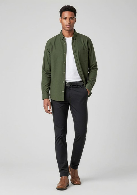 A man wearing black slacks and a green button-up shirt stands confidently, accessorised with brown shoes.