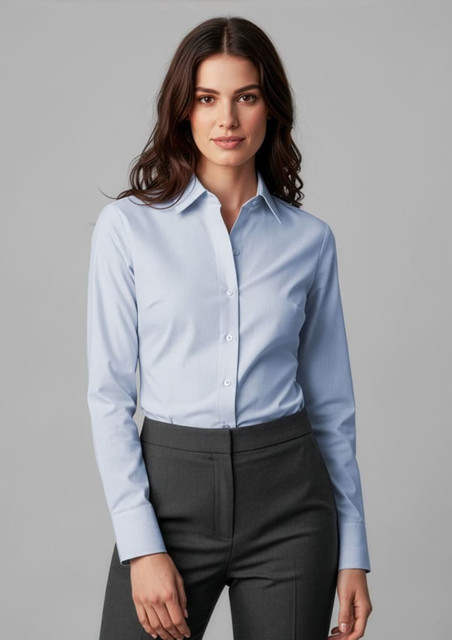 A light blue long sleeve button-up shirt worn with tailored grey pants. The shirt features a collar and has a logo.