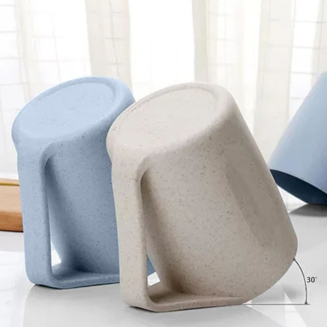 A reusable coffee cup set in light blue and beige, featuring a handle and a textured surface. Contains a logo.
