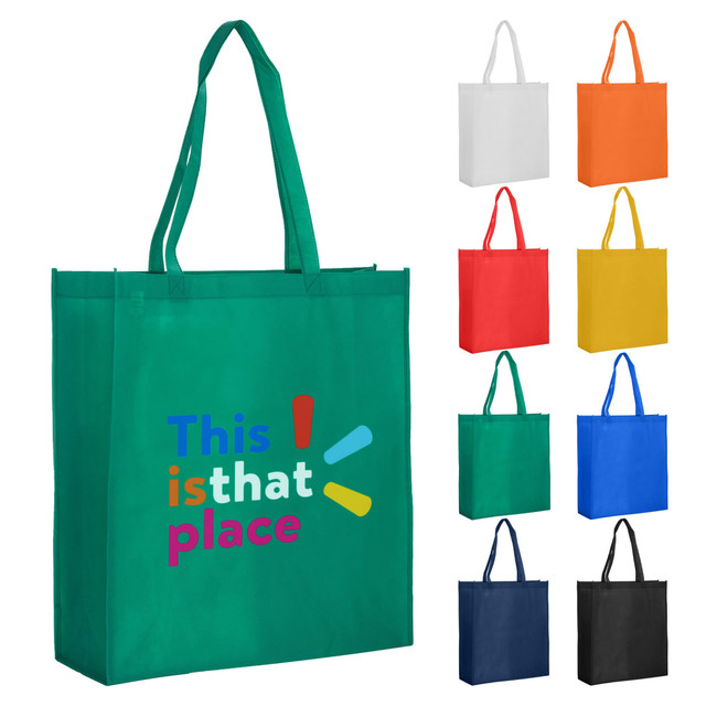 A green reusable grocery bag with two handles, featuring a logo, alongside bags in white, orange, red, yellow, blue, and black.