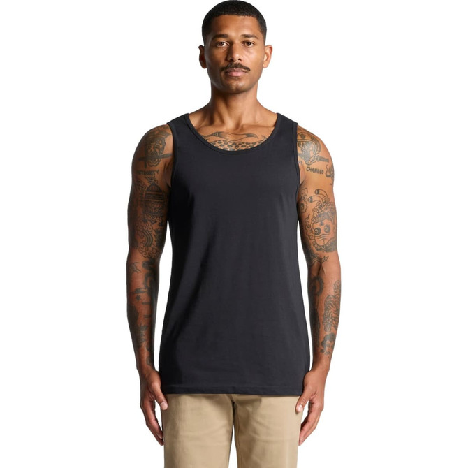 A man with tattoos wearing a black singlet. The singlet features a logo and has no sleeves.