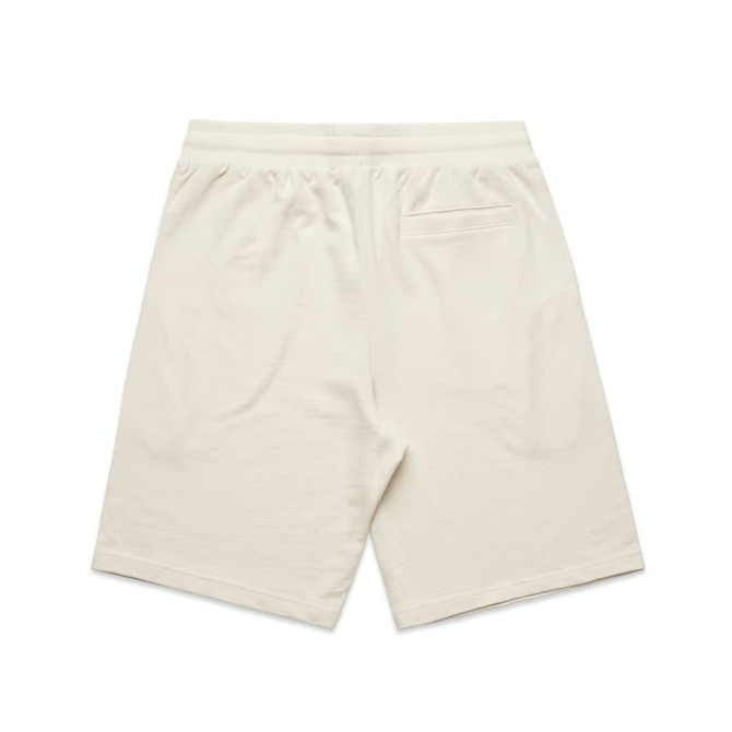 A pair of cream-coloured sports shorts featuring a back pocket and an elastic waistband.