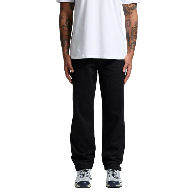 Black relaxed pants worn by a person standing, paired with a plain white t-shirt and athletic shoes.