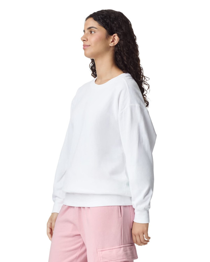 A white adult crewneck sweatshirt featuring long sleeves, displayed on a model with curly hair.