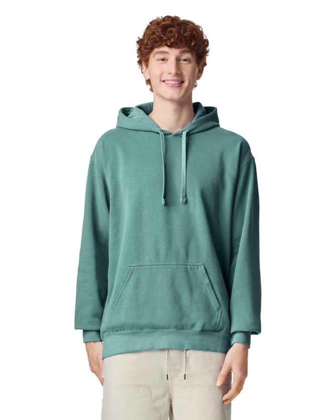 A teal adult hooded sweatshirt featuring a front pocket and drawstring hood, modelled by a smiling person.