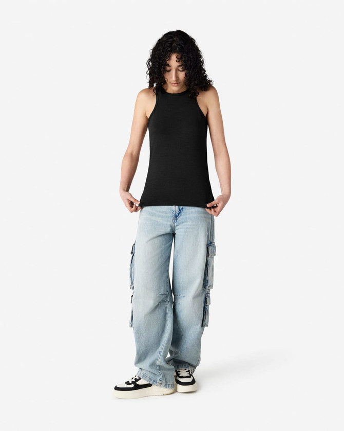 A black racerneck tank top with a fitted design, worn with light blue cargo pants and styled with black and white sneakers.
