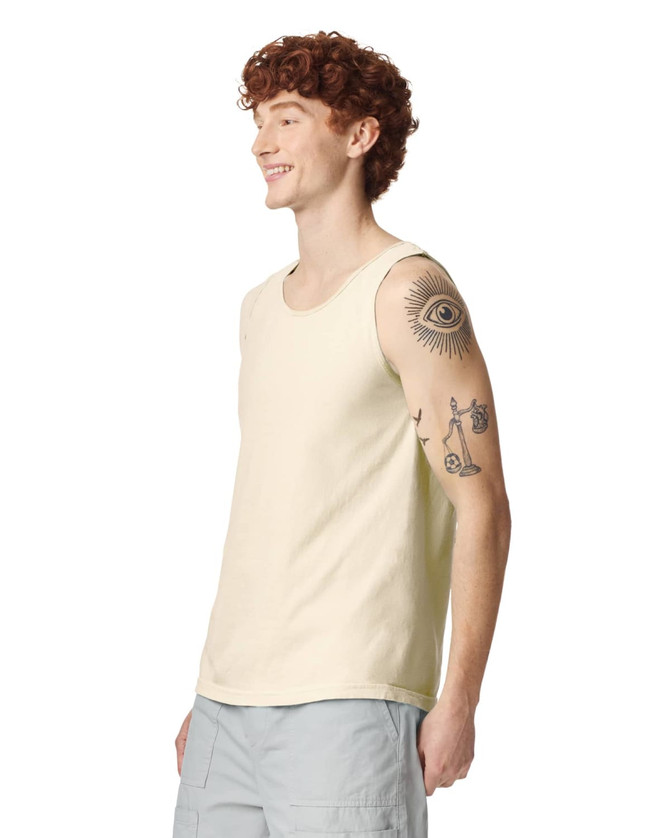 A light cream adult tank top displayed on a model with tattoos, featuring a logo on the side.
