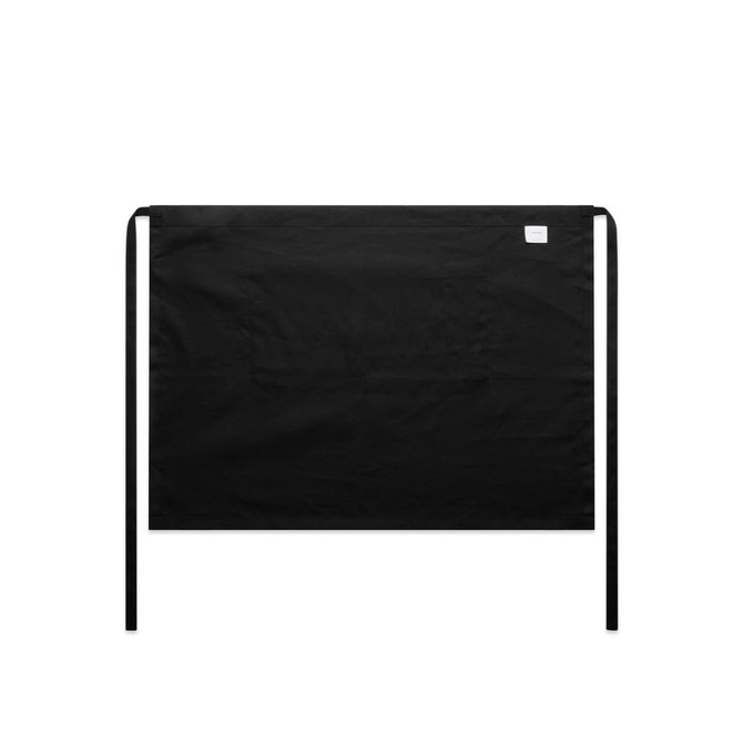 A black linen half apron with ties at the waist, featuring a small logo on one side.
