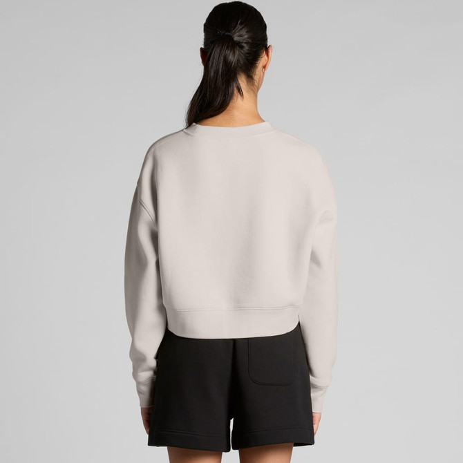 A light grey crop crew jumper viewed from the back, paired with black shorts. The design features a simple silhouette and a logo.