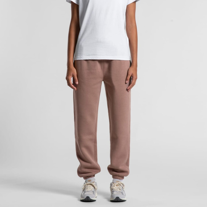 Relax track pants in a soft beige colour, featuring a tapered leg and ribbed cuffs. Model wears a plain white t-shirt.