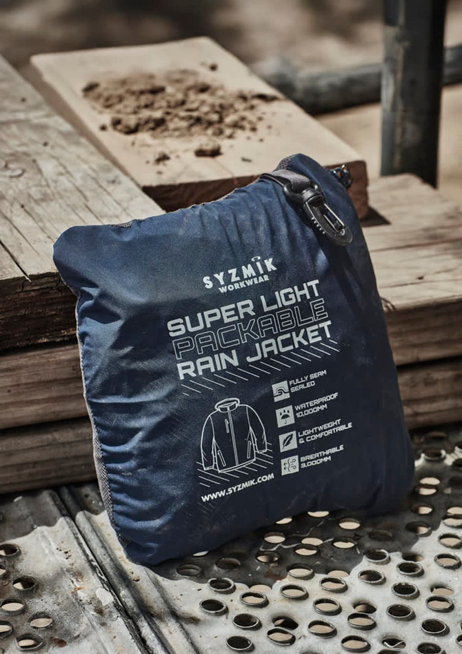 A navy blue packable rain jacket neatly folded and zipped, featuring a logo and information on the packaging.
